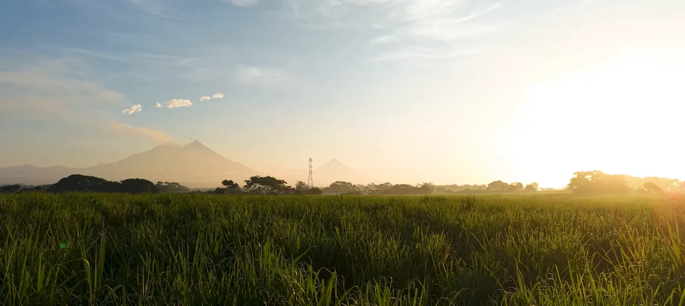 Amanecer sobre los campos con volcanes al fondo
